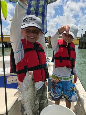 Boys holding fish and bait